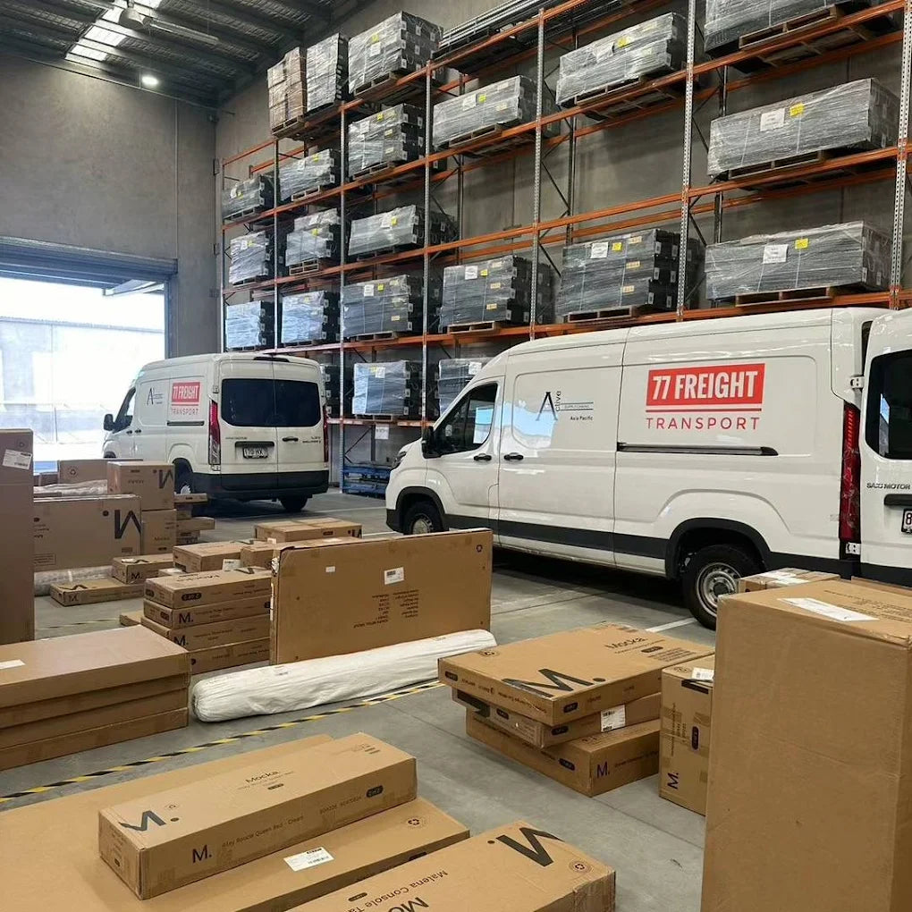 77 Freight Transport vans parked inside Brisbane warehouse with freight boxes ready for transport