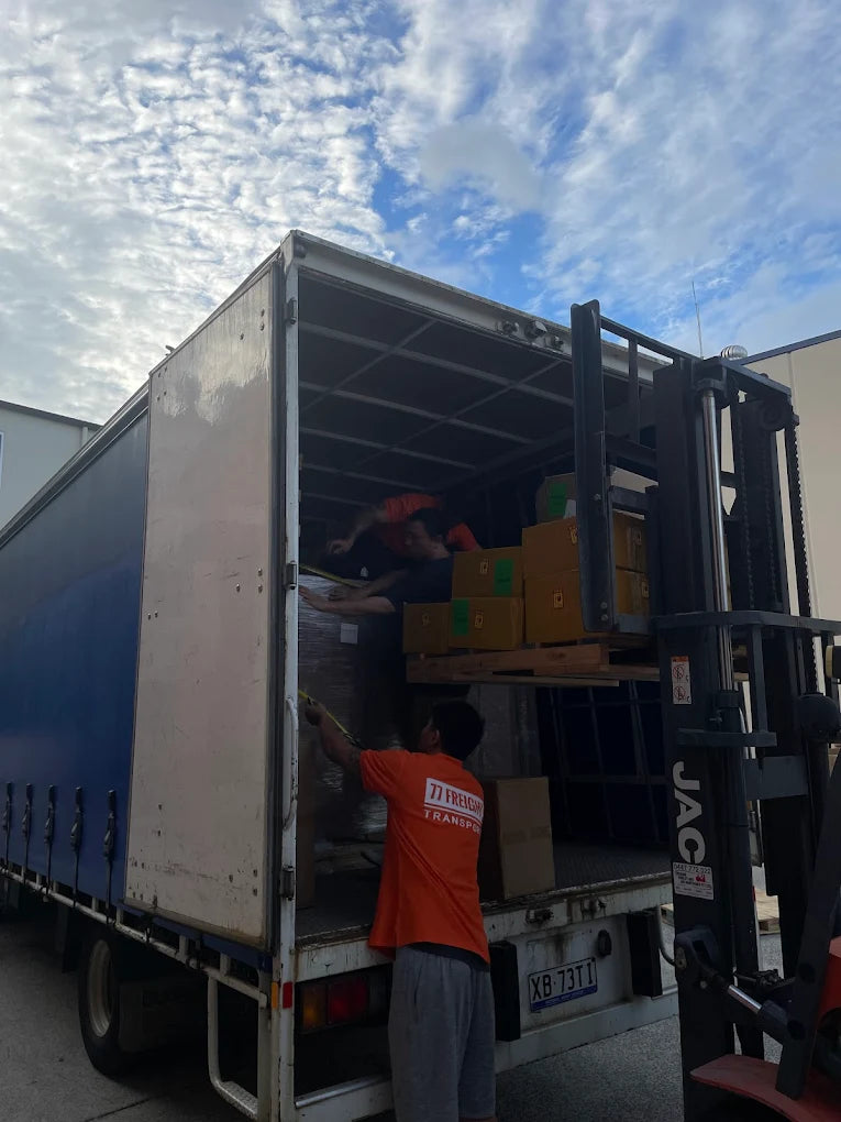 77 Freight Transport worker loading boxes onto truck for Brisbane freight delivery service