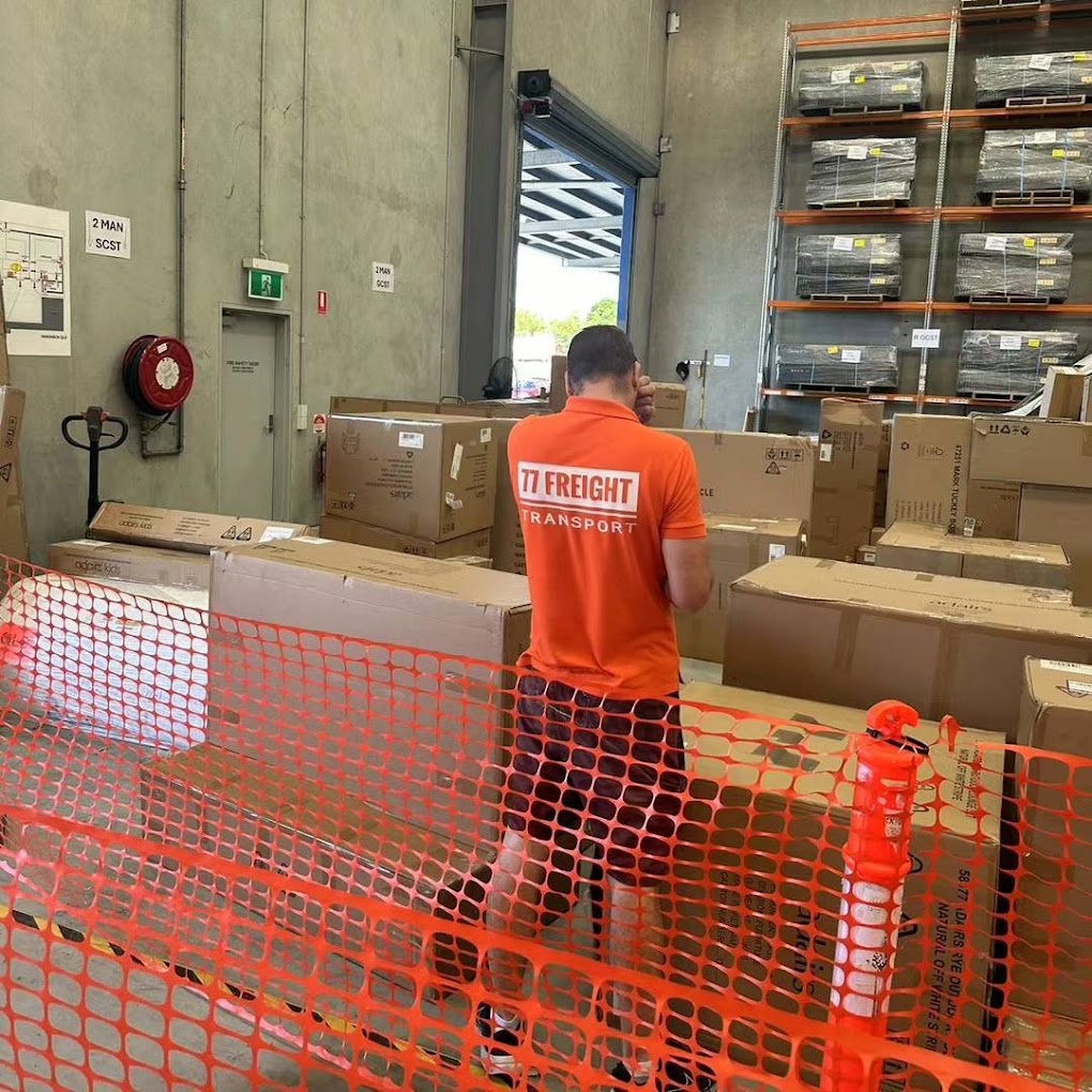 Person in an orange shirt with '17 Freight' logo in a warehouse setting.